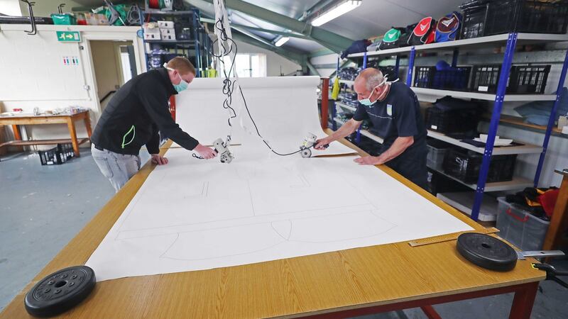 Intosport managing director Jonny Dowling and Joe Finnegan cutting out patterns