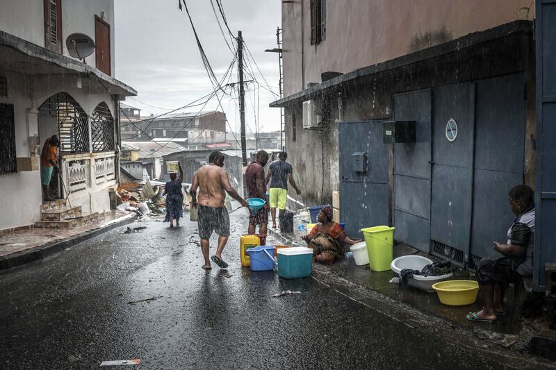 Residents collect water during a downpour in Mamoudzou. Photograph: Sergey Ponomarev/The New York Times