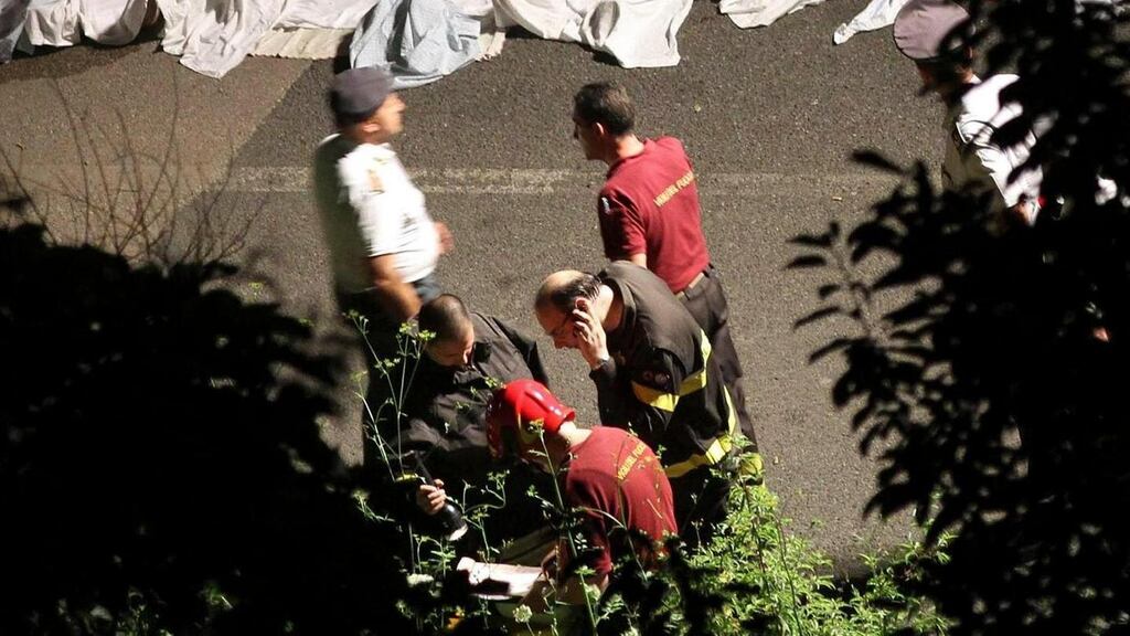 Members of the emergency services respond to the scene of the bus crash near Avellino last night