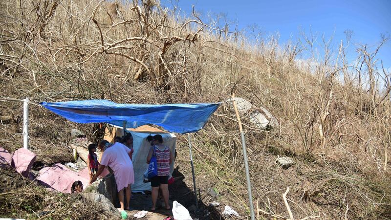 People bathe in a spring covered with a tarpaulin on a hillside in Yabucoa, eastern Puerto Rico, in the wake of damage caused by Hurricane Maria. Photograph: Hector Retamal/AFP/Getty Images