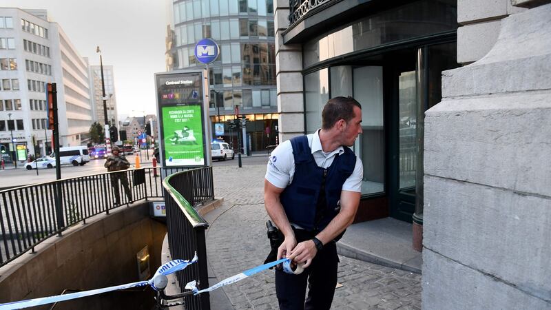 A police official uses tape to cordon off an area outside Brussels Central Station, after an explosion in the Belgian capital. Photograph: Emmanuel Dunand/AFP/Getty Images
