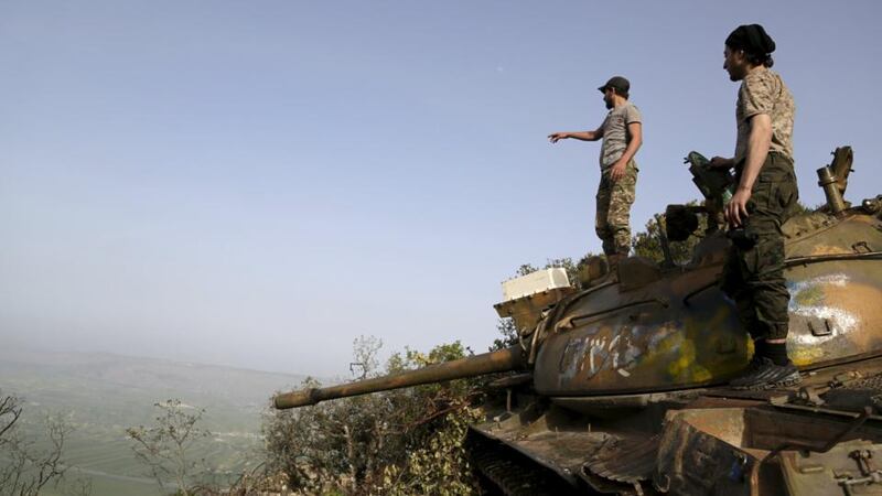 Rebel fighters stand on a tank overlooking al-Ghab plain, in the Jabal al-Akrad area in Syria’s northwestern Latakia province. Photograph: Khalil Ashawi/Reuters