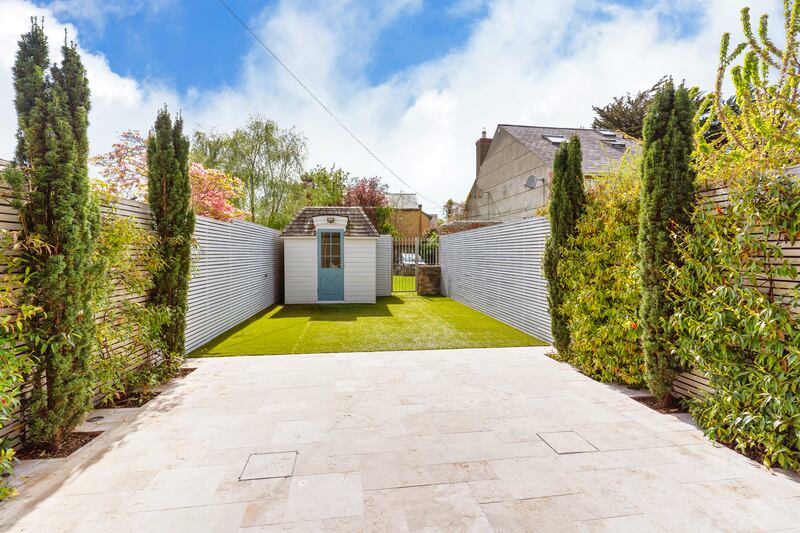 Southwest-facing rear garden with a shed and gate to communal garden