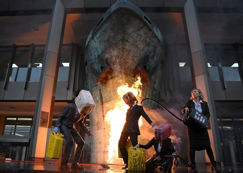 Oil Heads, climate activists from the Ocean Rebellion group, vomit mock oil as they demonstrate against the use of fossil fuels outside the offices of the International Maritime Organisation in London. Photograph: Daniel Leal/AFP via Getty Images