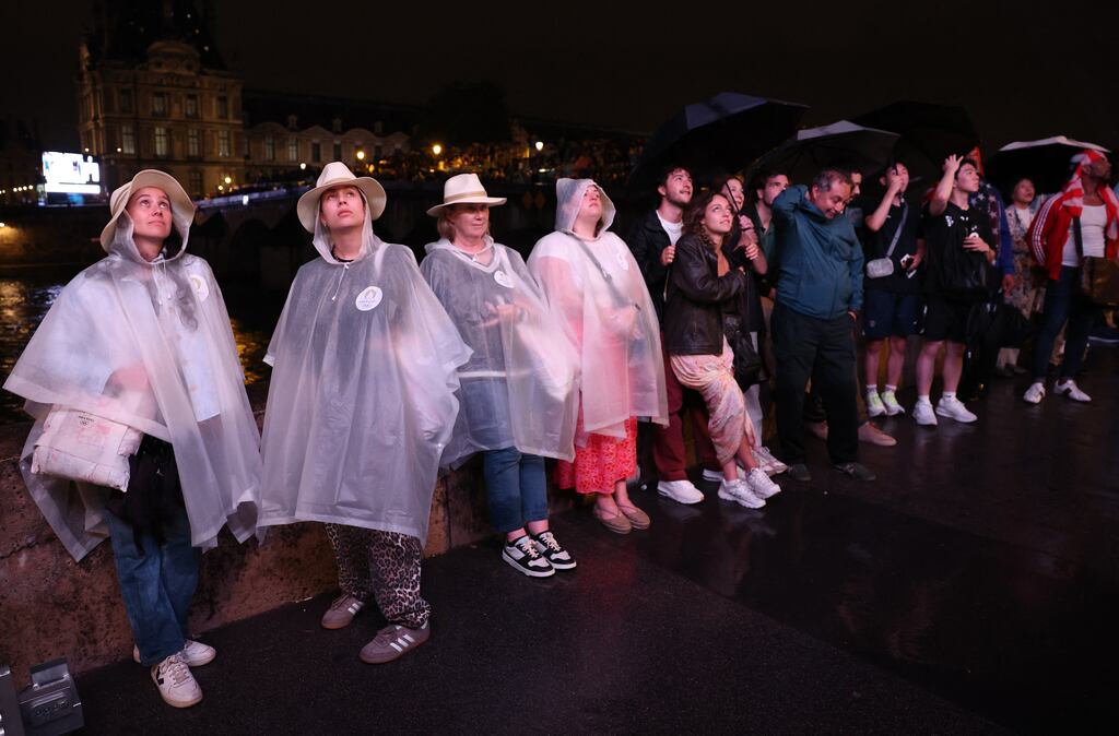 Spectators watch a large screen across the Seine river showing the Olympic Games opening ceremony in Paris. Photograph: Esa Alexander- Pool/Getty Images