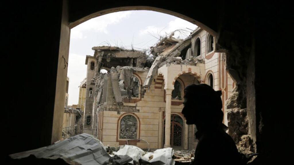An armed Yemeni stands walks amid the ruins of the house of a Yemeni army commander loyal to the Houthis after it was hit by two airstrikes allegedly carried out by the Saudi-led coalition in Sana’a, Yemen,  July 6th, 2015. Photograph: Yahya Arhab/EPA
