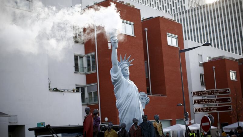 A replica of the Statue of Liberty is seen with smoke trailing out from its torch during a street parade as part of the ‘Global Village of Alternatives’ events held in Montreuil, near Paris in France. Photograph: Benoit Tessier/Reuters
