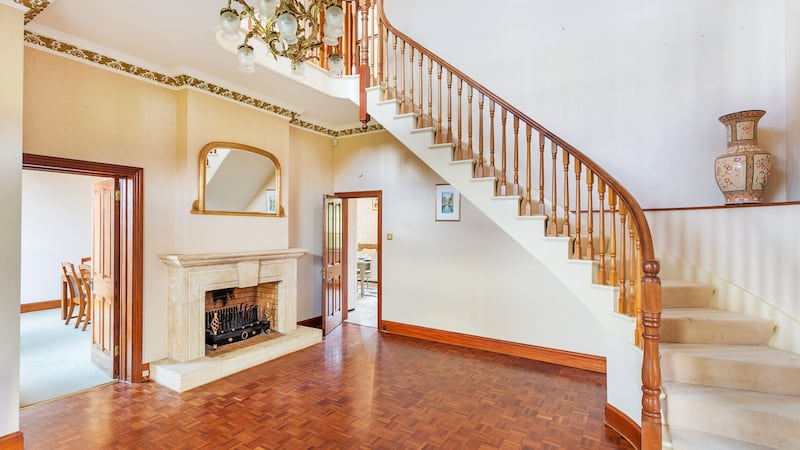 The entrance hall includes a hardwood floow and stone fireplace