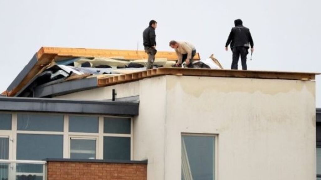 Workers repair a damaged roof on apartments at Churchwell Crescent in Belmayne, Dublin in September 2018. Photograph: Donall Farmer
