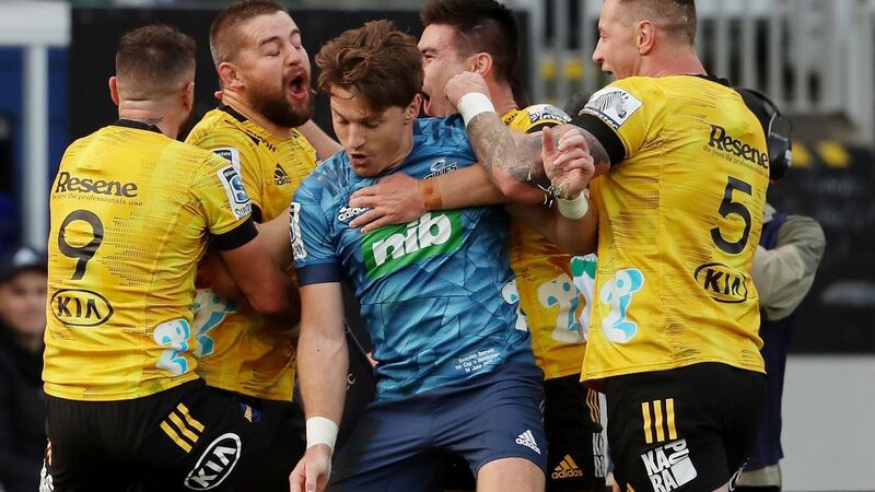 The Hurricanes’ players celebrate a try as Blues’ Beauden Barrett is caught in the middle. Photograph: Getty Images