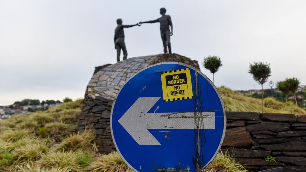 A sticker reading “No Border, No Brexit”  on a road sign near the Hands Across The Divide sculpture in Derry. Photographer: Mary Turner/Bloomberg