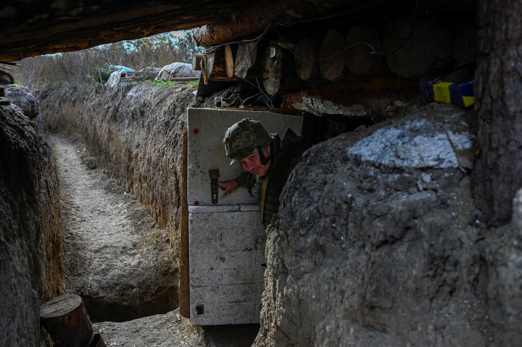 A Ukrainian soldier exits a foxhole dug into the side of a trench at the Kherson border region village, outside of Mykolaiv. Photograph: Bulent Kilic/AFP via Getty Images