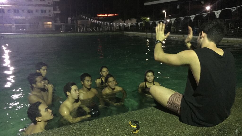Safety first: Andrew McLean discussing swimming strategies with the Zambales swim team