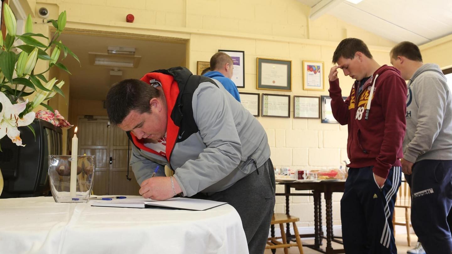 Dean King signs the book of condolences for the three Bolger brothers. Photograph: Mary Browne