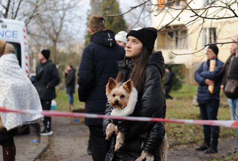 A woman holding a dog stands near the site of a damaged residential building on Friday after a Russian air strike on Lviv in western Ukraine. Photograph: Mykola Tys/EPA-EFE