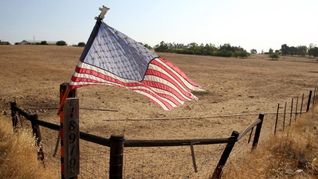 An American flag is posted on a fence in front of a dry unplanted field in Lodi, California. As the severe drought in California contiues to worsen, the majority of the State’s major reservoirs are at or below 50 percent of capacity with some nearing the 20 percent mark. Photograph: Justin Sullivan/Getty Images