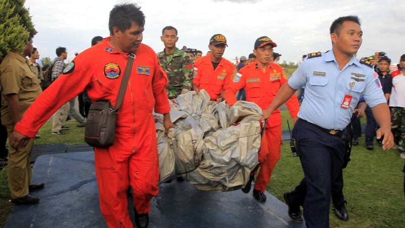 Members of an Indonesian Air Force crew carry what is believed to be an emergency slide from the AirAsia plane which was recovered during the search and rescue operation. Photograph: Bagus Indahono/EPA