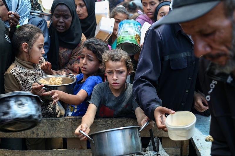 Palestinians gather to receive a hot meal at a food distribution point in the Nuseirat camp for refugees in the central Gaza Strip on Wednesday. Photograph: Eyad Baba/AFP via Getty Images
