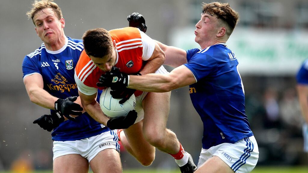 Armagh’s Niall Grimley is challenged by  Pádraig Faulkner and Conor Brady of Cavan during the Ulster SFC semi-final at  St Tiernach’s Park in  Clones. Photograph: Ryan Byrne/Inpho