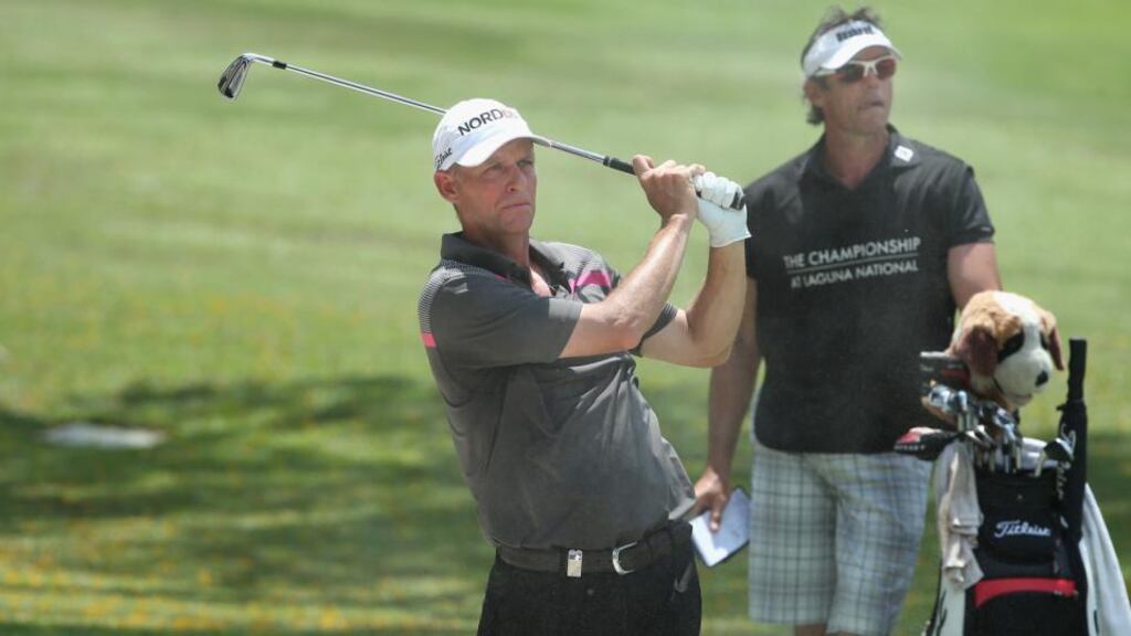 Anders Hansen of Denmark plays his second shot on the 15th hole with his caddie Nick Mumford in the background on day three of The Championship at Laguna National in Singapore. Photograph: Andrew Redington/Getty Images