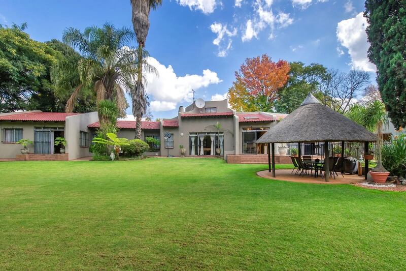 Gardens at the property in Gauteng, South Africa have a pool, gazebo and built-in bar