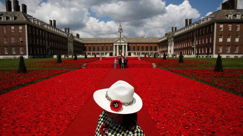 A volunteer stands at the entrance of the 5,000 Poppies Garden at the Chelsea Flower Show in London. Photo: Getty Images