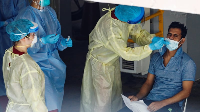 A migrant worker undergoes a nose swab test as medical workers look on at a dormitory amid the coronavirus disease outbreak in Singapore on Monday. Photograph: Edgar Su/Reuters
