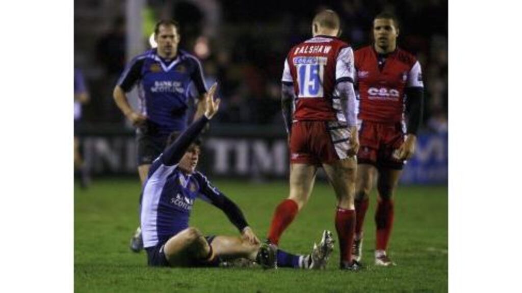 Shane Horgan holds his injured knee and signals for attention
before being helped from the field during last evening's European
Cup Pool Two match between Gloucester and Leinster at
Kingsholm.