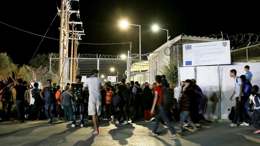 Refugees and migrants stand at the closed gate of the Moria migrant camp, after a fire at the facility, on the island of Lesbos, Greece. Photograph: Intimenews/Manolis Lagoutaris/via Reuters