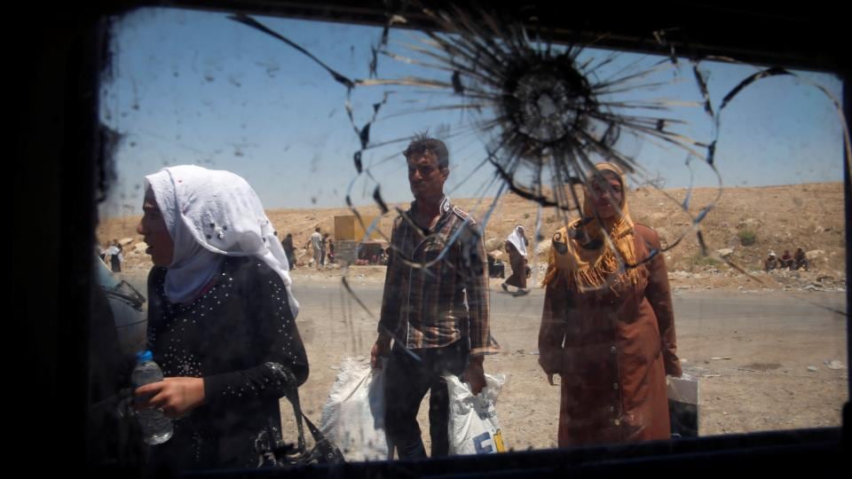 Displaced Iraqi civilians seen through a shattered window of an Iraqi forces vehicle in Mosul. Photograph: Erik De Castro/Reuters