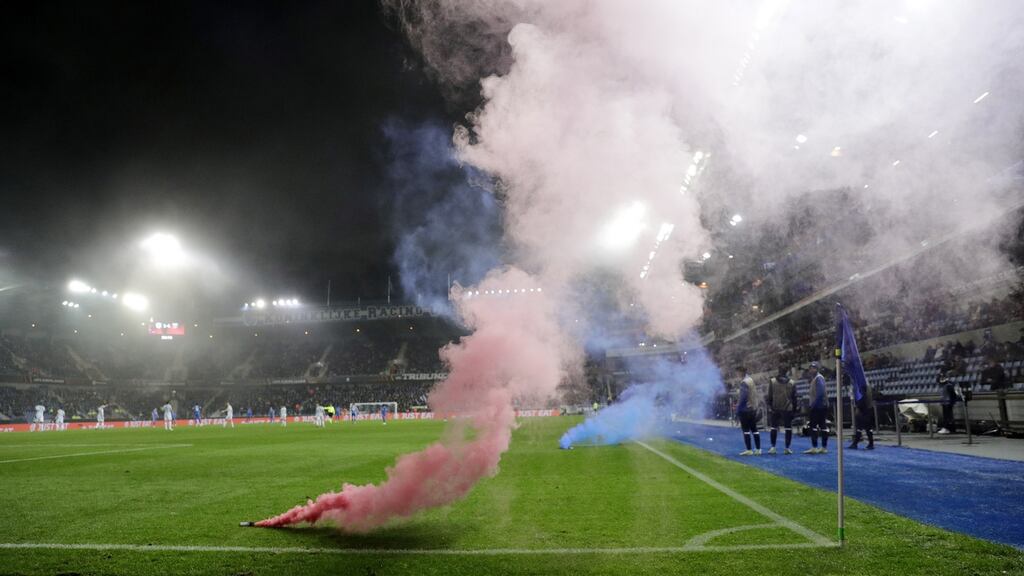 Flares on the pitch during the match between Genk and West Ham. Photo: Olivier Hoslet/EPA