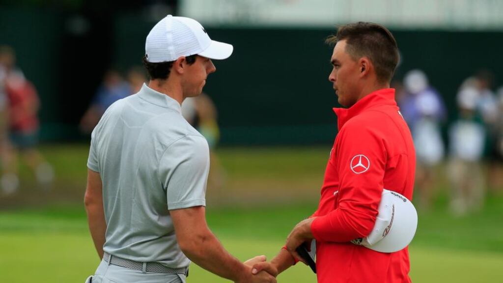 Rory McIlroy and Rickie Fowler shake hands on the 18th green after their first rounds. Photo: Rob Carr/Getty Images