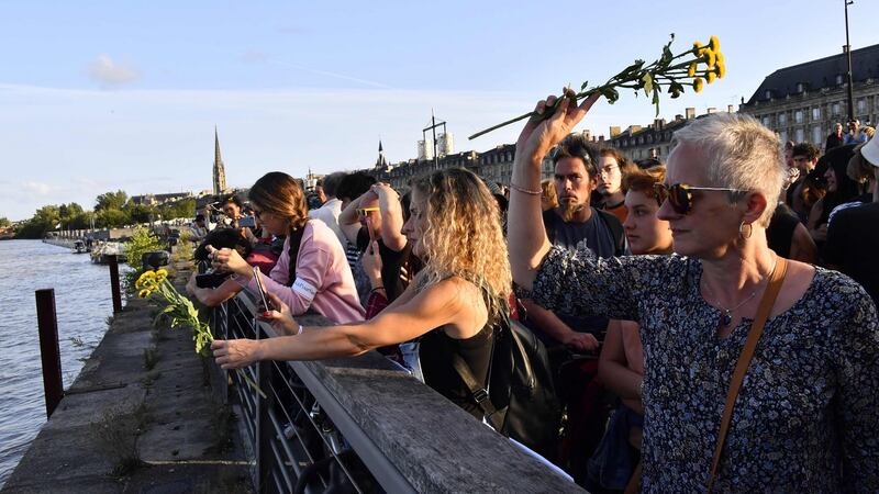 Activists throw flowers into the Garonne river in Bordeaux on Tuesday, in a tribute to Steve Maia Caniço, who died after falling into the river Loire in Nantes following a police raid on a music festival in June. Photograph: Mehdi Fedouach/AFP/Getty Images