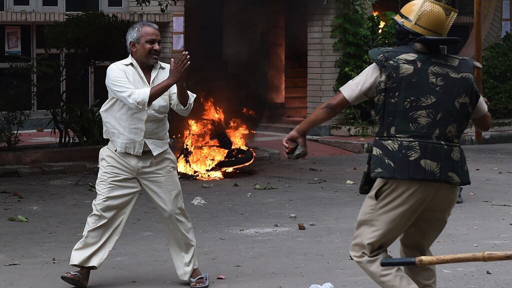 A follower of Indian religious leader Gurmeet Ram Rahim Singh pleads for his safety after being hit with a stick during clashes between the controversial guru’s followers and security forces in Panchkula on Friday. Photograph: Money Sharma/AFP/Getty Images