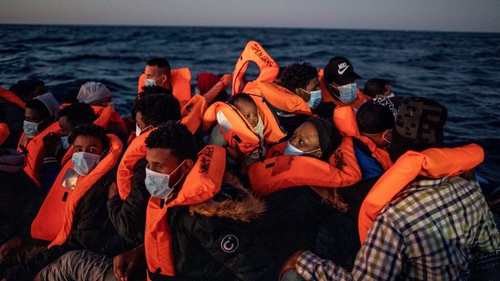 A woman holds a three-month-old baby as migrants and refugees from different African nationalities wait for assistance on an overcrowded rubber boat in the Mediterranean Sea. File Photograph: AP/Bruno Thevenin