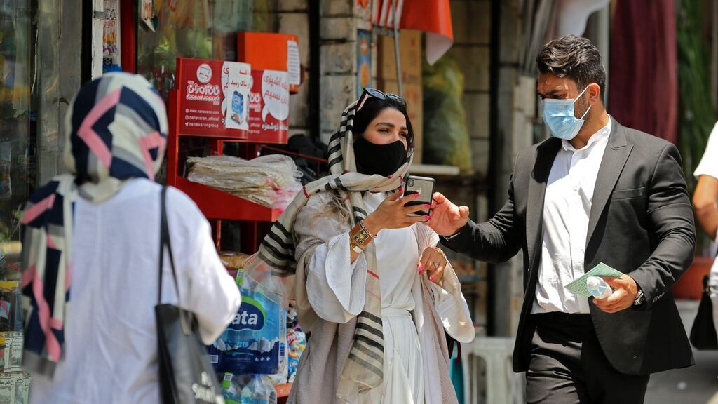 Iranian pedestrians wearing protective masks due to the Covid-19 pandemic, walk along a street in the capital Tehran. We have been living through what the Bank for International Settlements in its latest annual report, calls a “global sudden stop”. Photograph: AFP