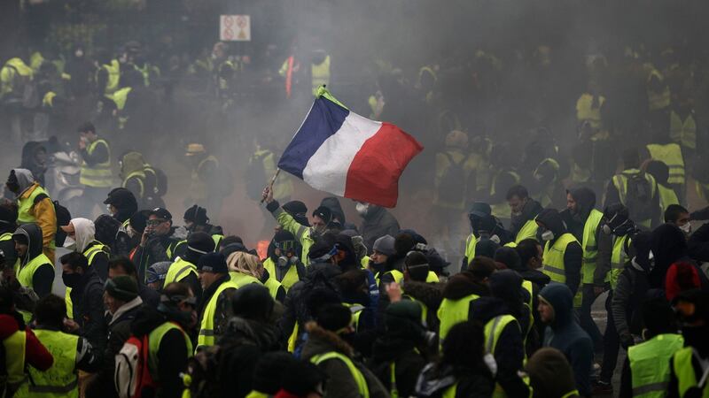 A Demonstrator holds a French flag near the Champs-Elysees during a Yellow Vests demonstration in Paris on Saturday, December 1st Photograph: Kamil Zihnioglu/AP