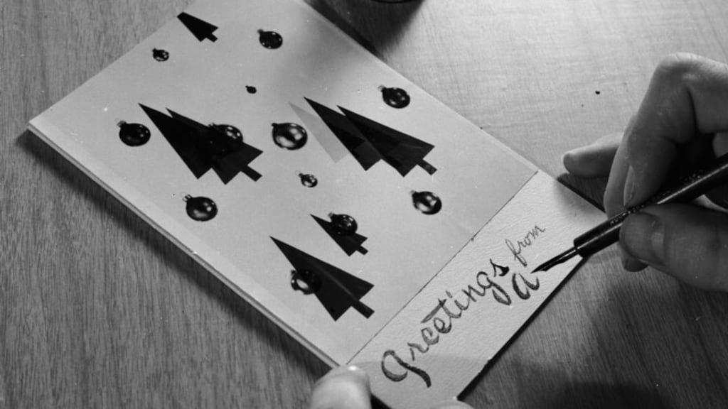 The finishing touches are applied to a home made Christmas card. Photograph: Three Lions/Getty Images