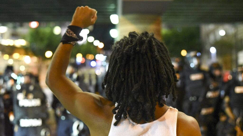 A protester with raised fist confronts riot police officers in Charlotte, North Carolina. Photograph: Caitlin Penna/EPA