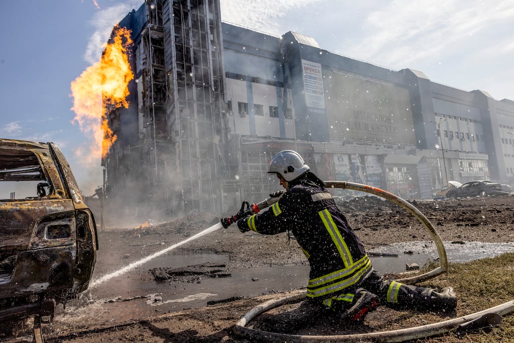 A Ukrainian firefighter works to extinguish a burning car after what Ukrainian officials said was a Russian missile strike in Kharkiv, Ukraine. Photograph: David Guttenfelder/New York Times