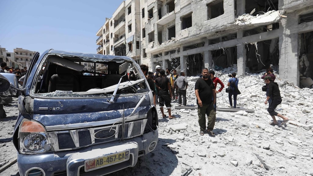 Syrians gather at a site of car bomb in the northwestern Syrian city of Idlib. Photograph: Omar Haj Kadour/AFP/Getty Images