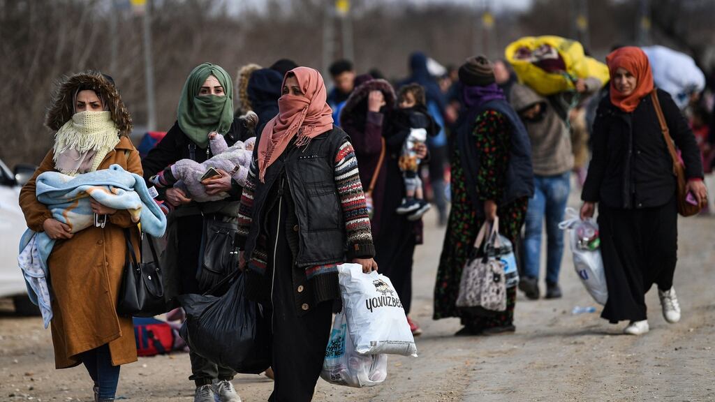 Migrants carry belongings towards the Pazarkule border gate in Edirne in northwest Turkey as they try to enter Europe. Photograph: Ozan Kose/AFP