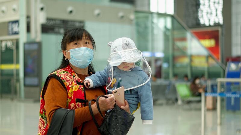 A passenger wearing and a baby wait for a train at Hefei railway station in Hefei, in Chinas eastern Anhui province which borders Hubei province. Photograph: AFP via Getty Images