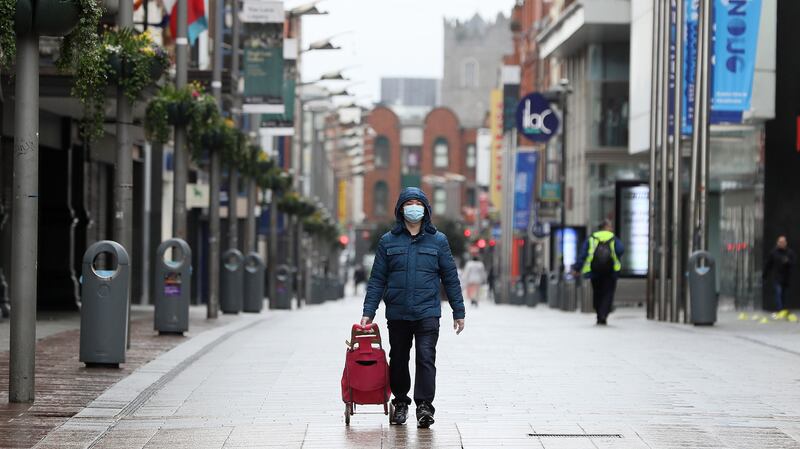 A man walks down an almost deserted Henry Street in Dublin on Easter Sunday. Photograph: Brian Lawless/PA Wire