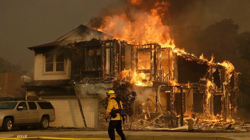 A firefighter walks near a home in Santa Rosa, California, the US, as wildfires spread through northern California. Photograph: Jeff Chiu/AP Photo