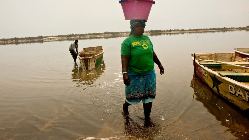 A Senegalese woman carry a heavy load of salt on to the shore at Lac Rose. Photograph: Lar Boland