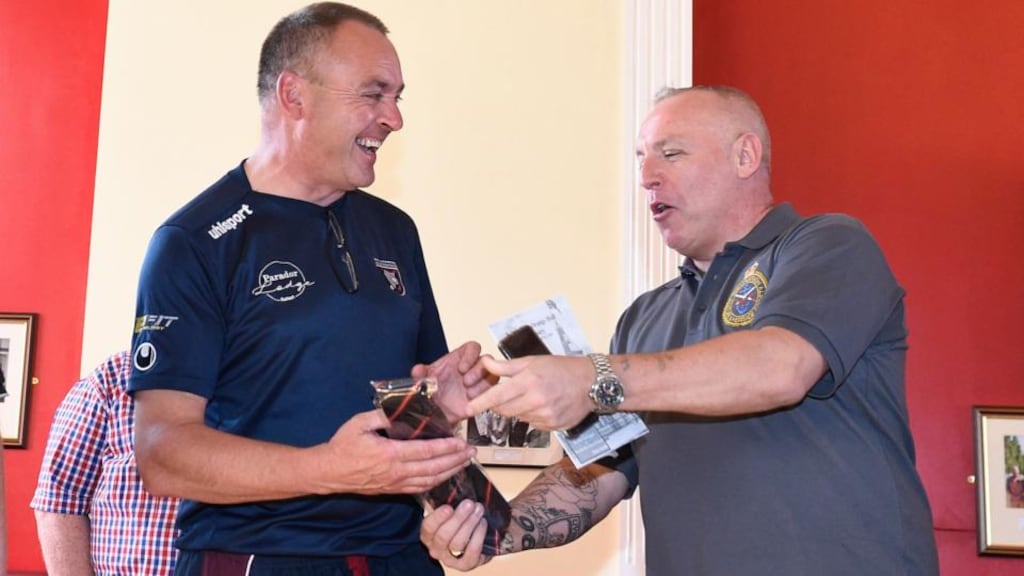 Malcolm McFarlane (l), chair of Bredagh GAC, receives a gift from Stephen Biggerstaff during a tour of the Ballynafeigh Orange Hall in Belfast. Photograph: Michael Cooper/PA Wire