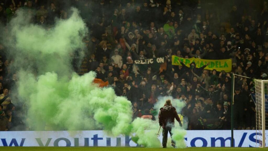 Celtic fans throw flares on to the pitch before the Scottish Premiership match at Fir Park, Motherwell. Photograph: Jeff Holmes/PA