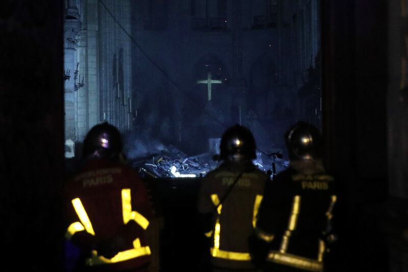 Firemen enter the cathedral as flames burn the roof. Photograph: Yoan Valat/EPA