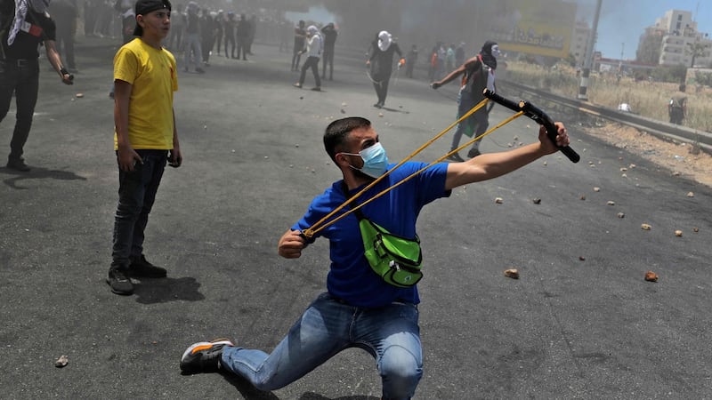 A Palestinian protester uses a slingshot to hurl stones at Israeli security forces amid clashes near the settlement of Beit El and Ramallah in the occupied West Bank. Photograph: Abbas Momani/AFP via Getty Images